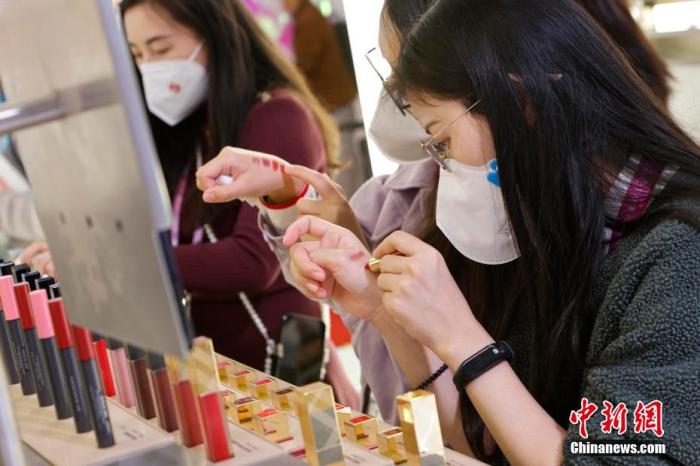 圖為女生正在體驗(yàn)口紅產(chǎn)品。 殷立勤 攝