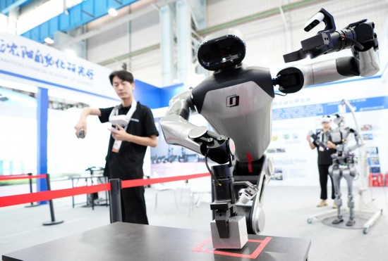 9月5日，在沈陽的2025全球工業(yè)互聯(lián)網(wǎng)大會(huì)的展覽區(qū)現(xiàn)場，中國科學(xué)院沈陽自動(dòng)化研究所的機(jī)器人工程師在調(diào)試具身智能操作系統(tǒng)。新華社記者 李鋼 攝