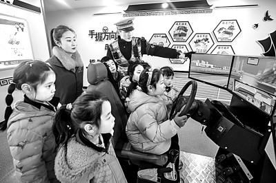 山東省榮成市公安局道路交通安全宣傳教育基地，交警帶領(lǐng)小學(xué)生現(xiàn)場體驗(yàn)?zāi)M駕駛。新華社發(fā)