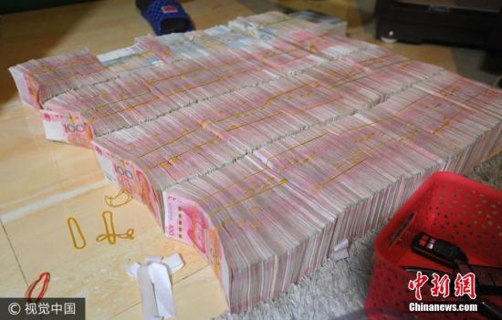 廣西南寧警方8月21日通報，當(dāng)?shù)亟粘晒善粕姘附痤~15.19億元人民幣的特大傳銷案件。圖為當(dāng)場繳獲的成捆現(xiàn)金。圖片來源：視覺中國