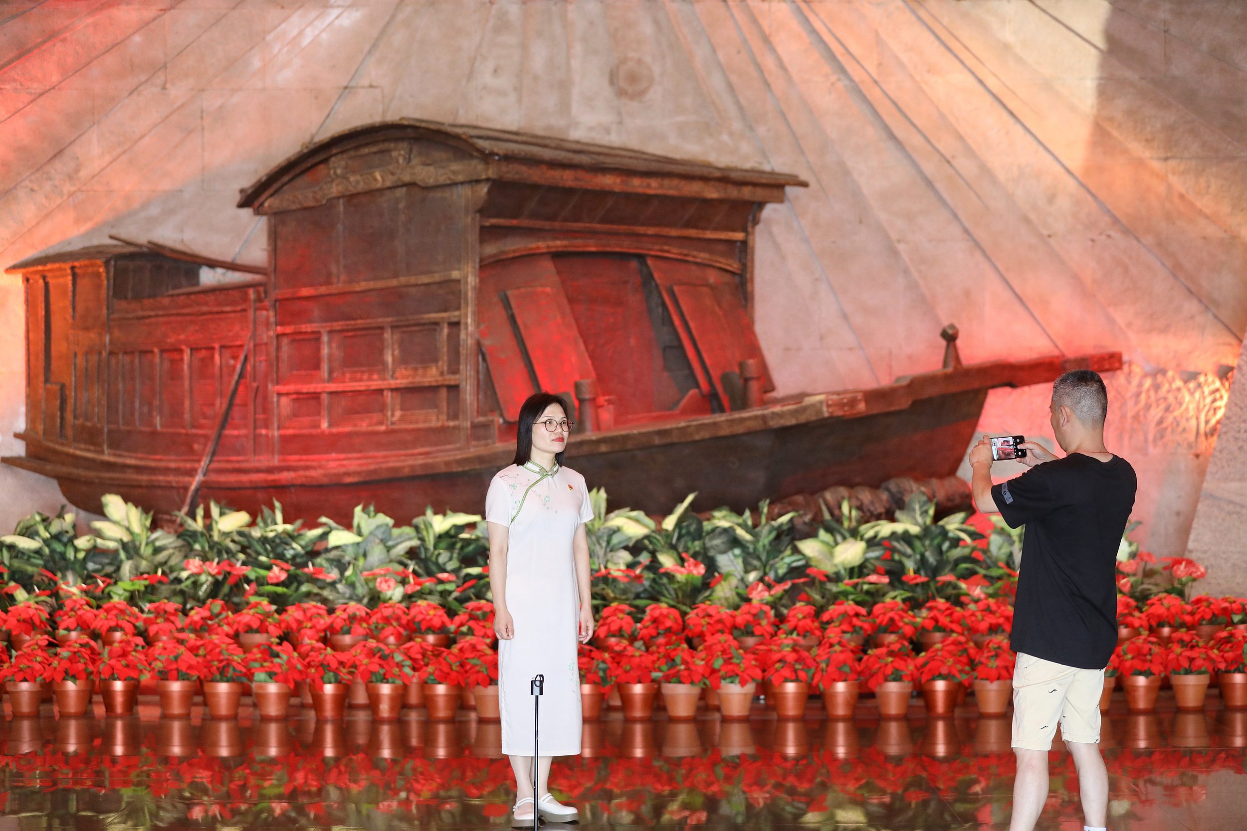 2025年6月24日，浙江嘉興，游客在南湖革命紀念館與紅船雕塑合影。（圖片來源：視覺中國）